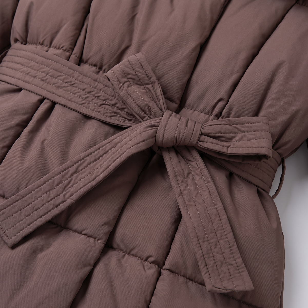 Haven puffer coat tied belt and quilting close-up
