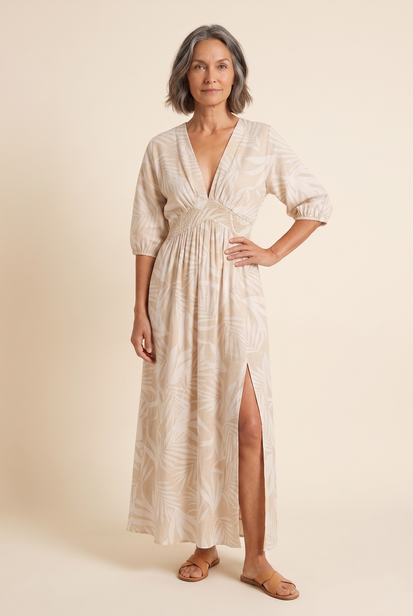 Women's beige tropical print A-line maxi dress, front view on model, warm cream studio background