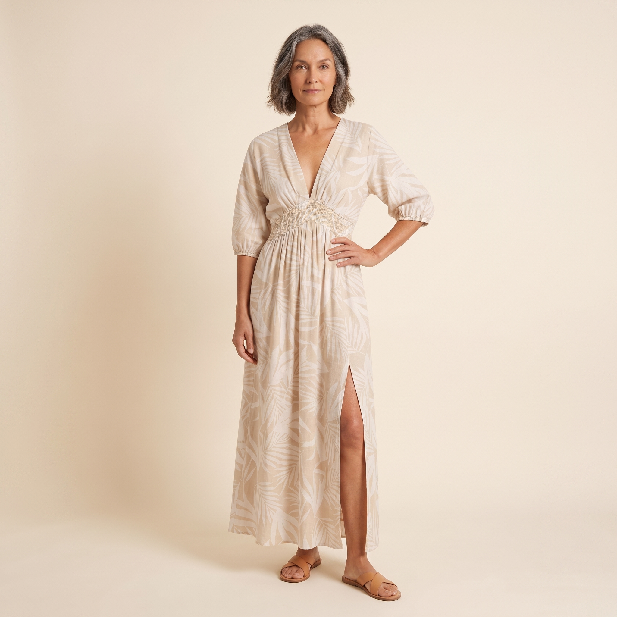 Women's beige tropical print A-line maxi dress, front view on model, warm cream studio background