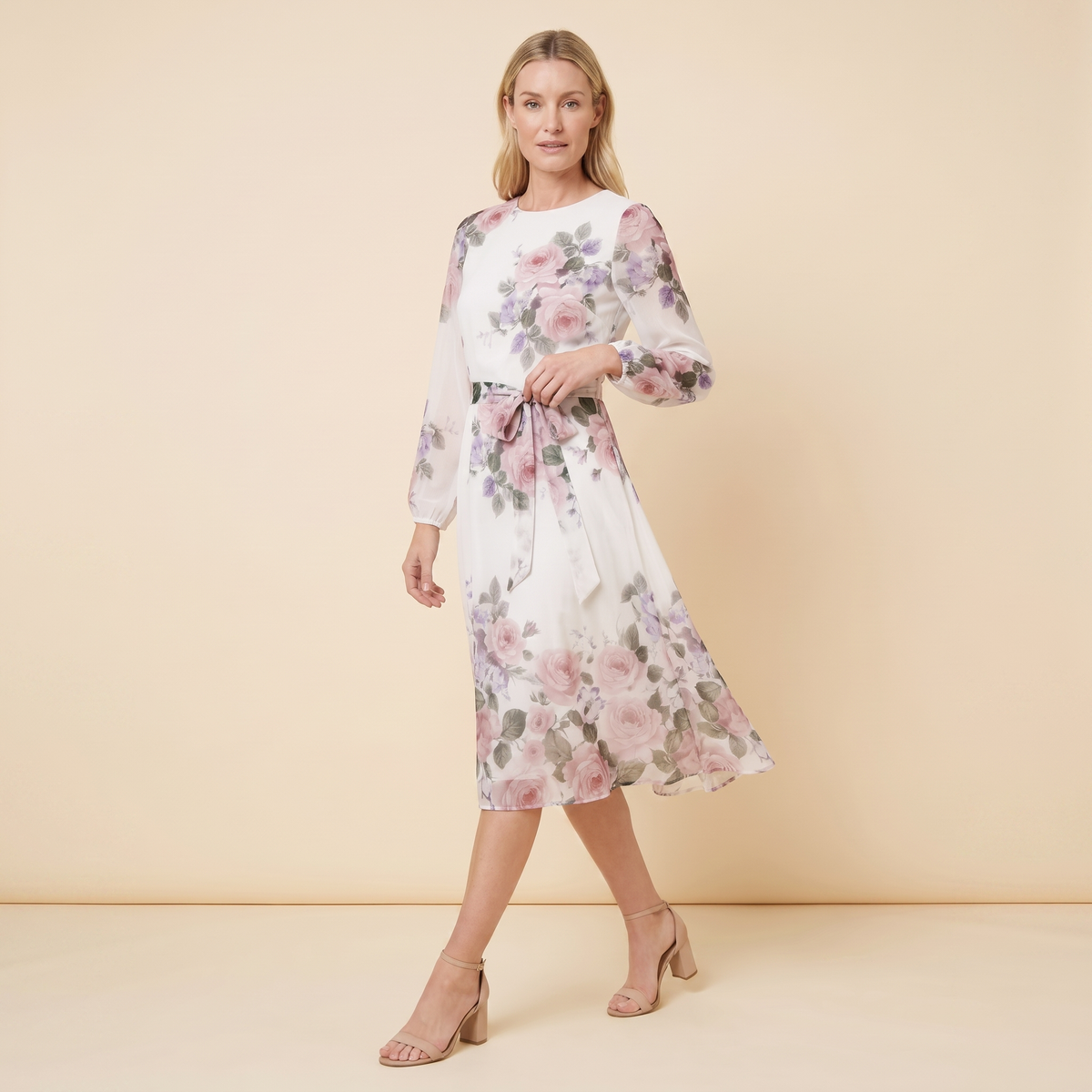 Model wearing white floral A-line midi dress with tie belt, walking pose
