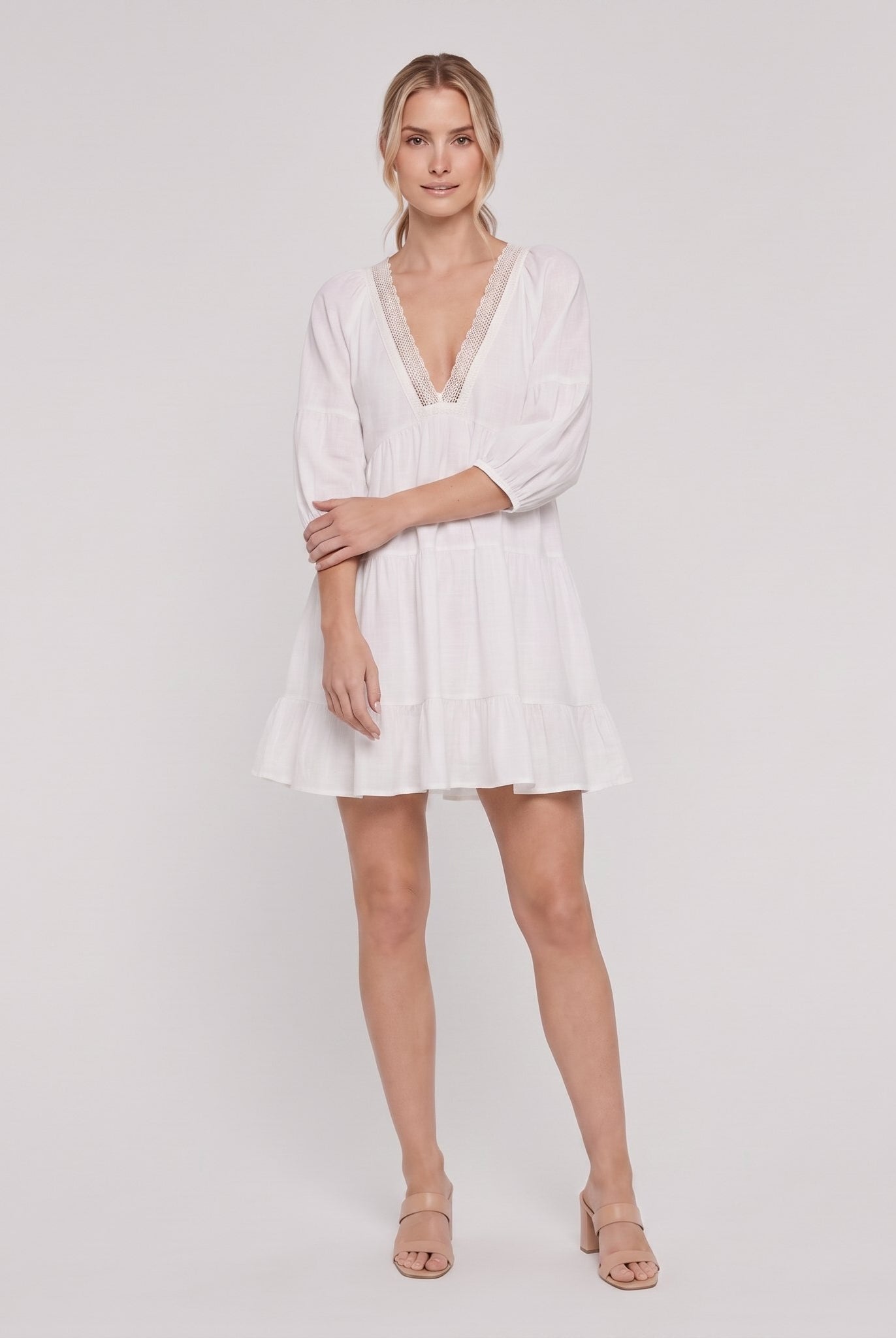 White cotton-linen tiered mini dress with lace V-neck, full-length view