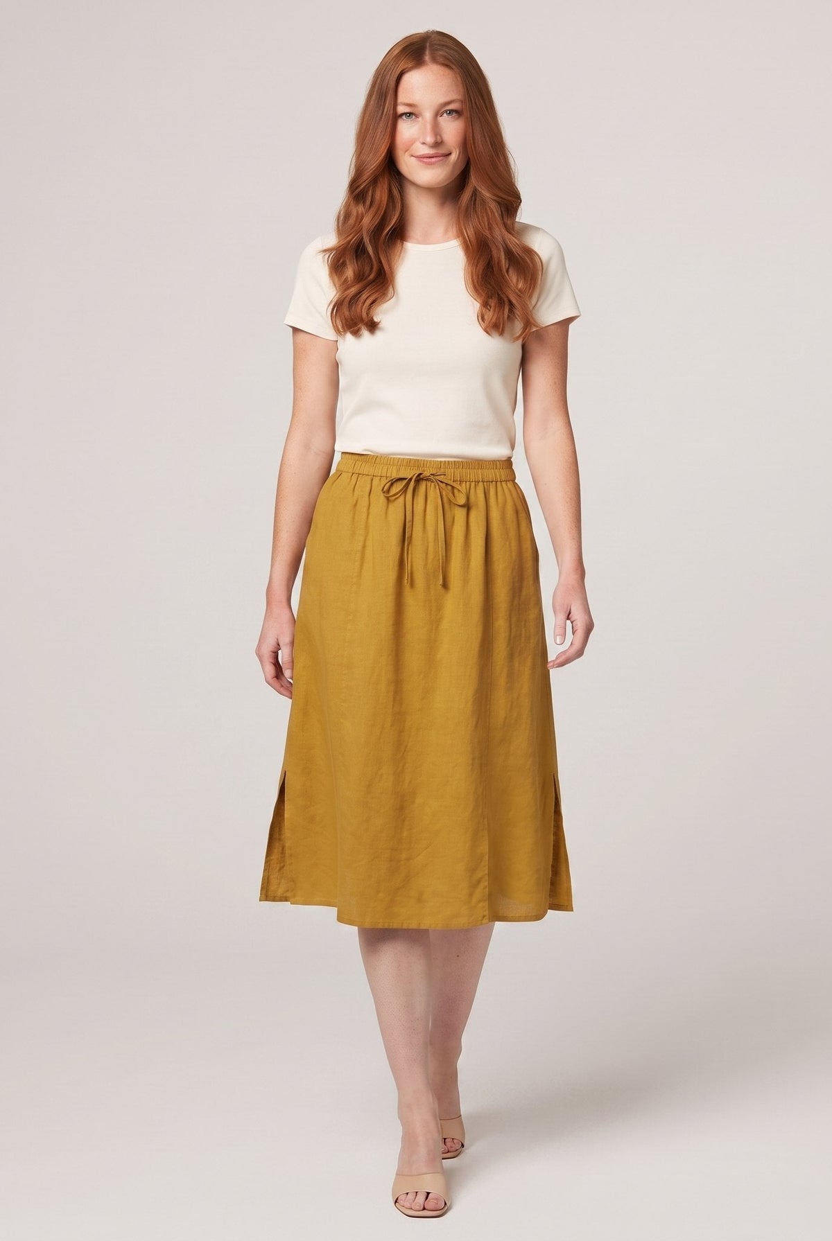 Mustard yellow linen A-line knee-length drawstring skirt, front view on model