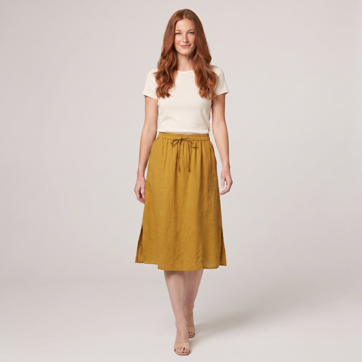 Mustard yellow linen A-line knee-length drawstring skirt, front view on model