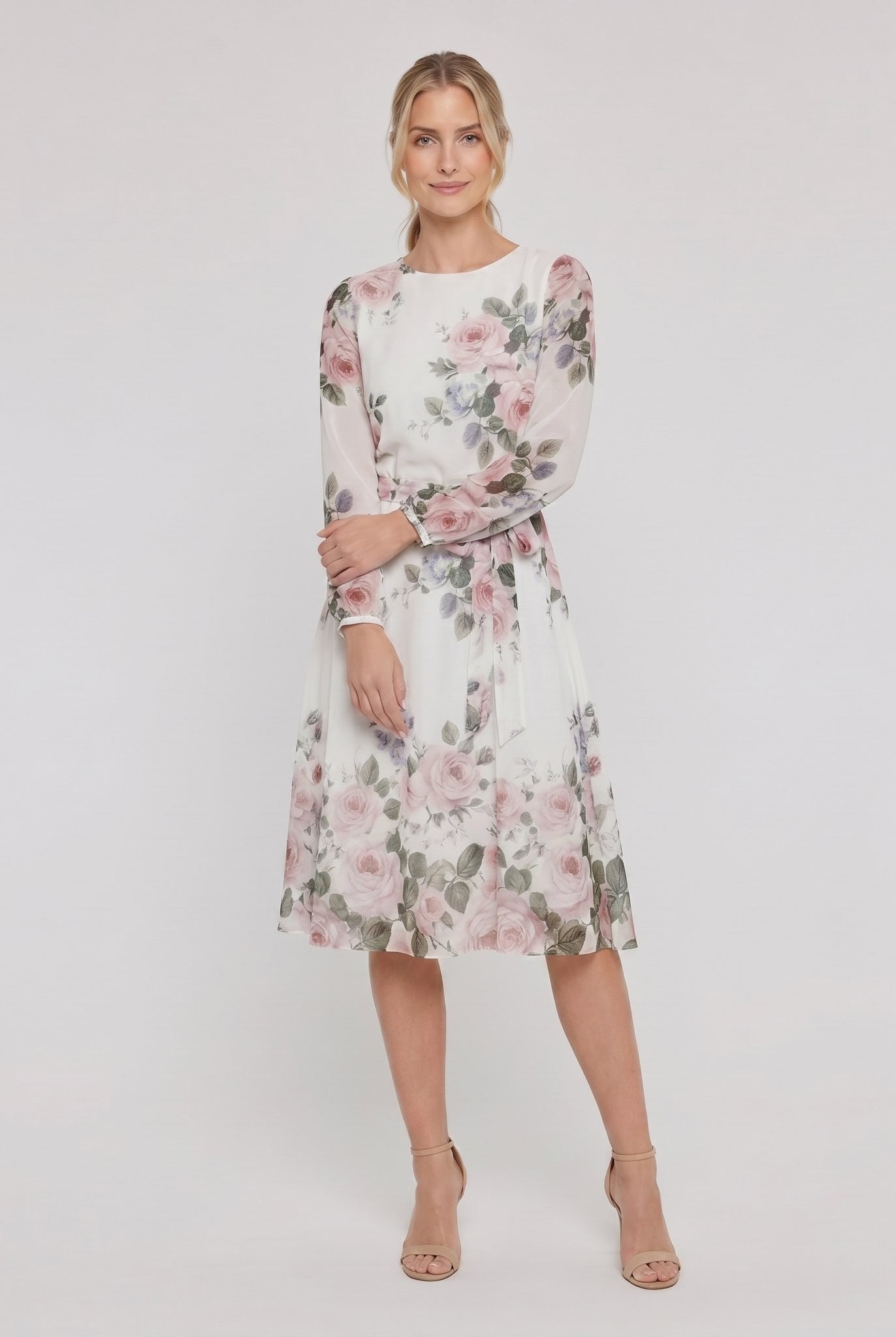 Model wearing white floral A-line midi dress with tie belt, relaxed pose