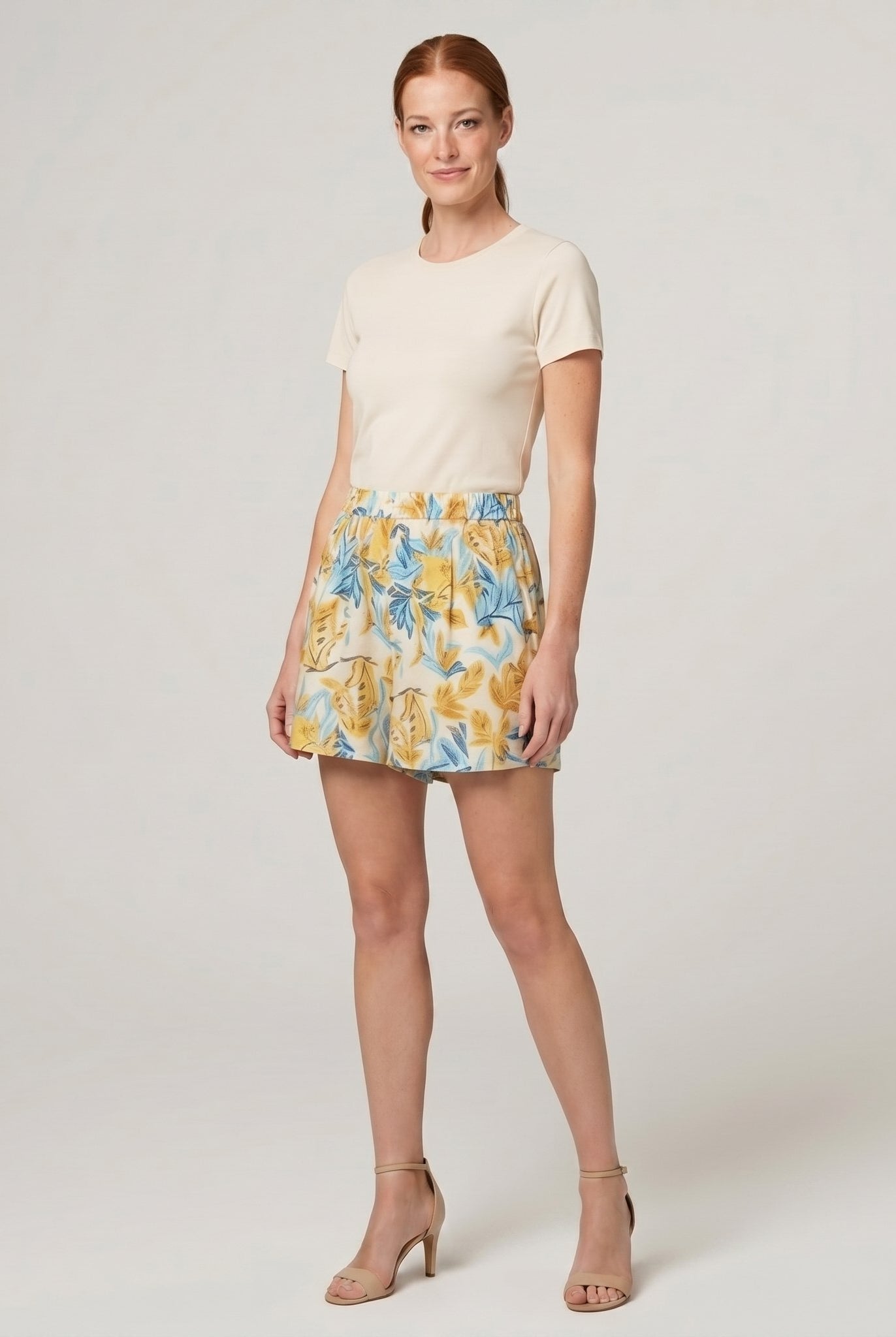 Pamela Boutique beige floral A-line pleated shorts, model angle pose