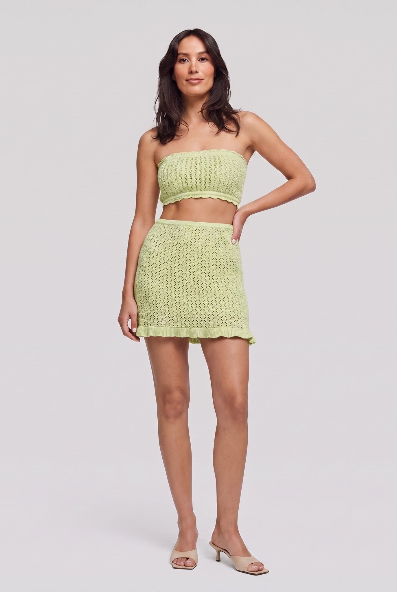 Lime green knit two-piece set, strapless bandeau crop top and ruffle-hem mini skirt, front view