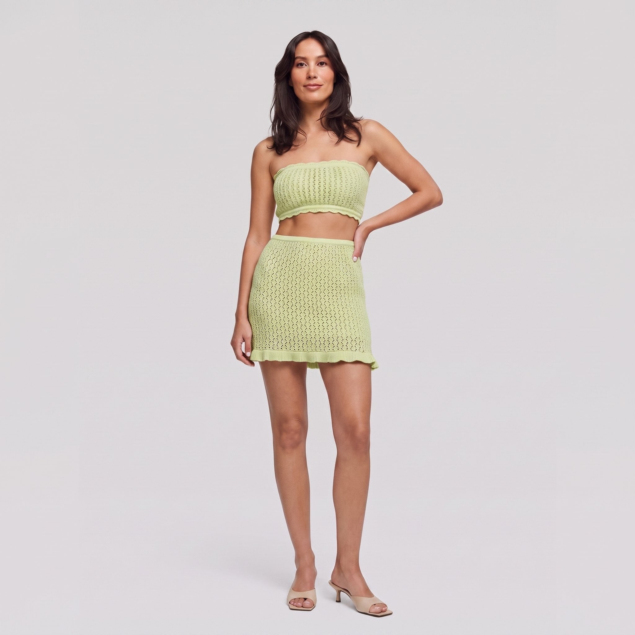 Lime green knit two-piece set, strapless bandeau crop top and ruffle-hem mini skirt, front view