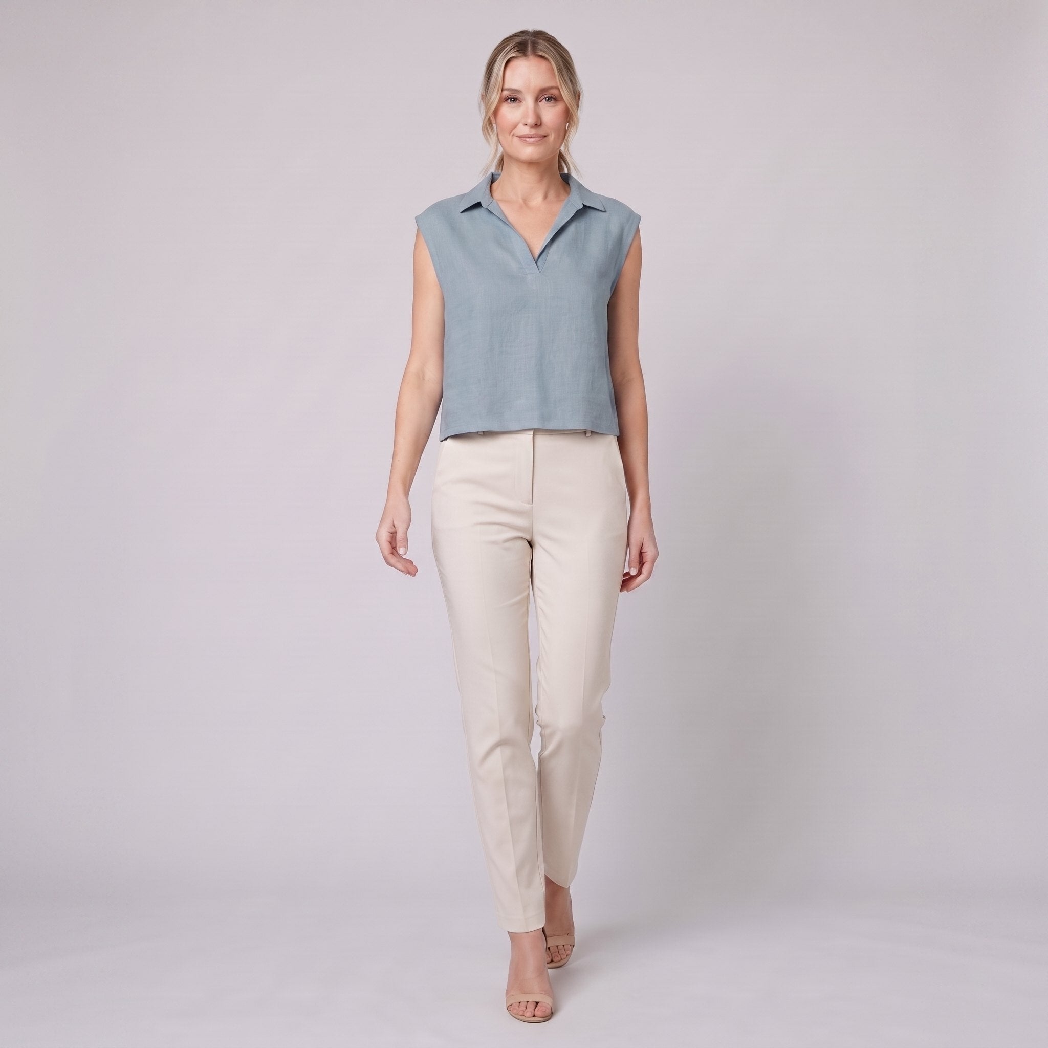 Sky blue linen sleeveless crop top with open collar, on model