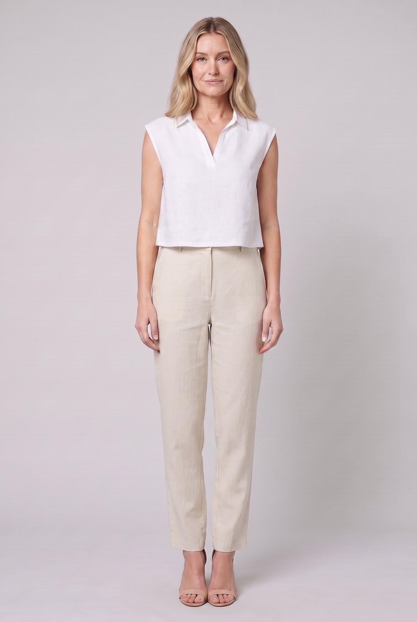 White sleeveless linen crop top with open collar, front view on model