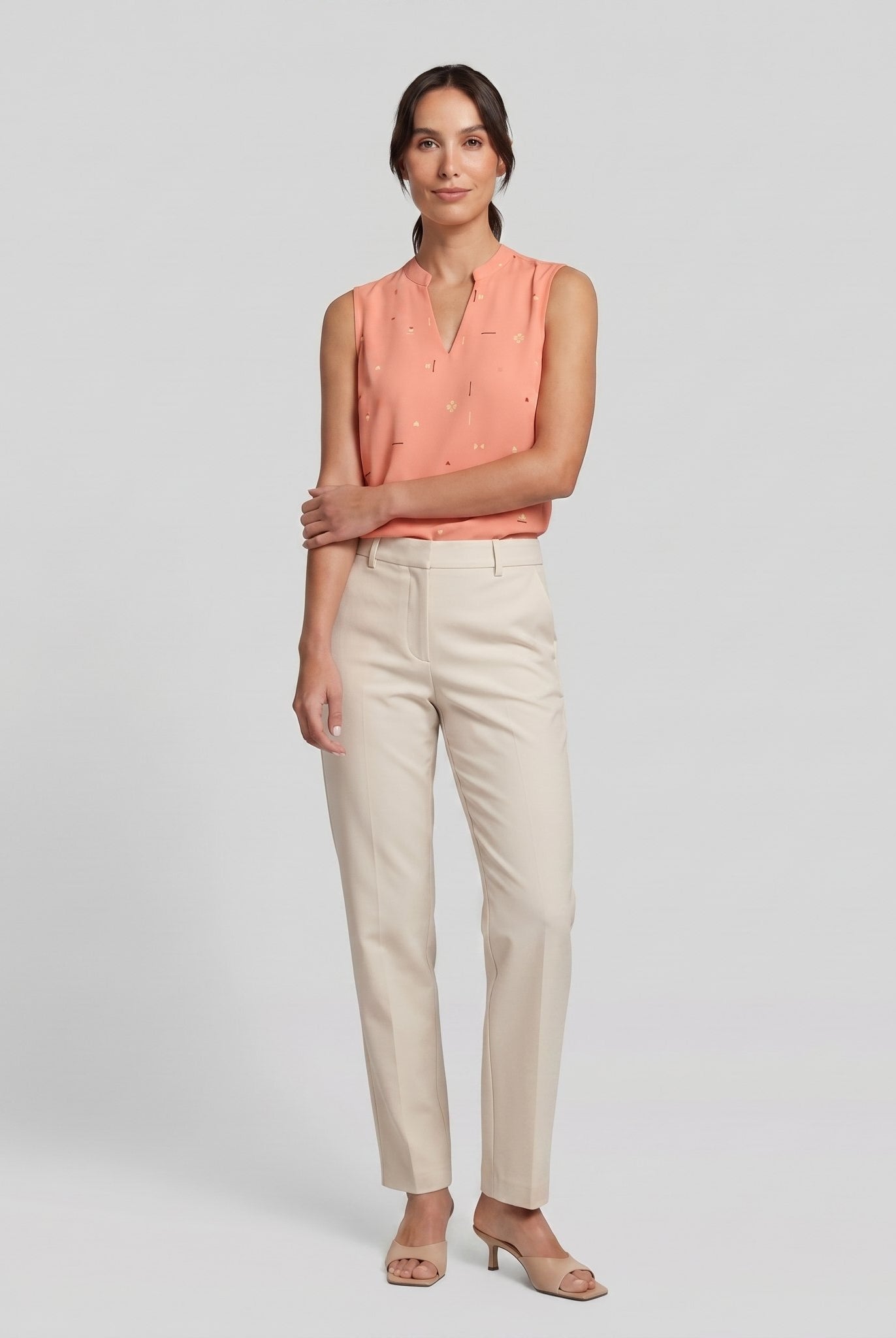 Pamela Boutique peach sleeveless V-neck blouse, model side pose