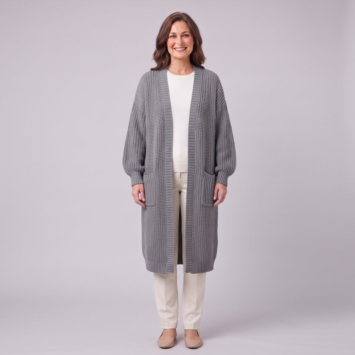 Halla longline chunky rib cardigan in grey, front view on model with cream trousers