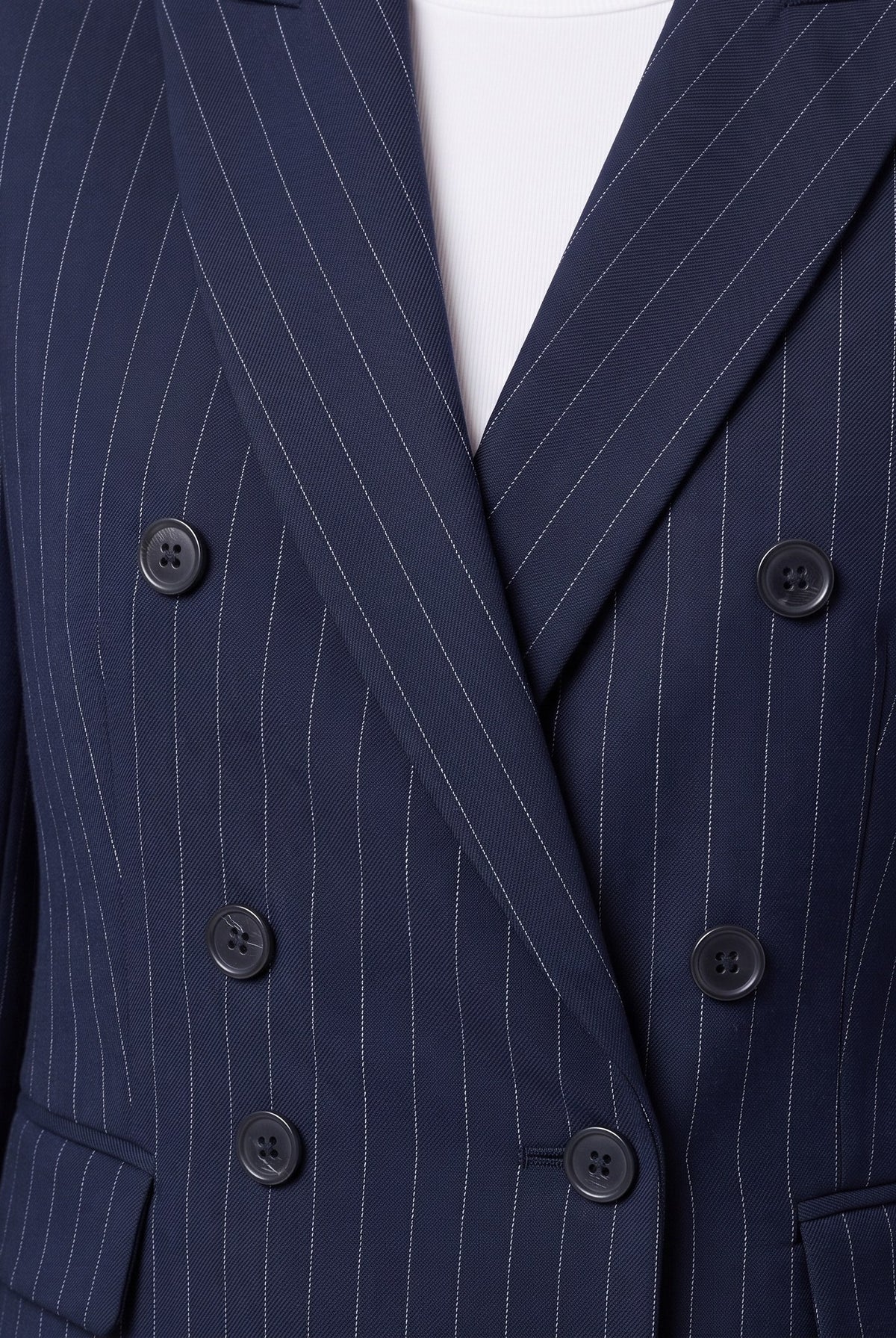 Close-up of the double-breasted buttons and pinstripe weave on the Iris suit
