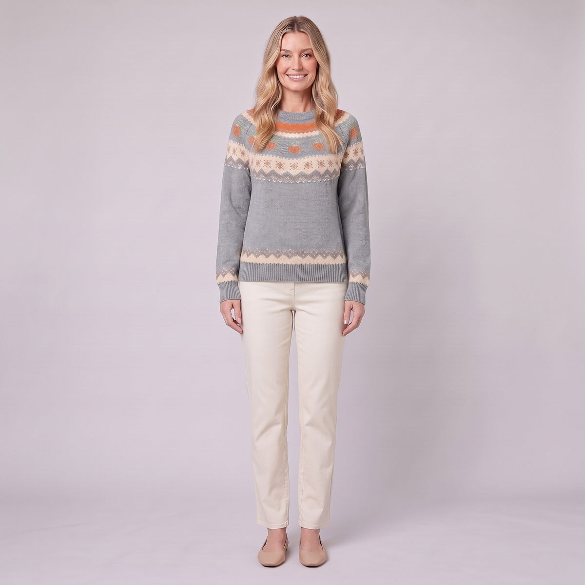 Nieve pumpkin fair isle sweater in grey, front view on model with cream trousers