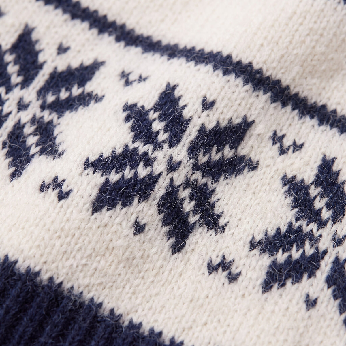 Nova snowflake knit sweater fabric detail, Nordic snowflake jacquard close-up in navy on cream