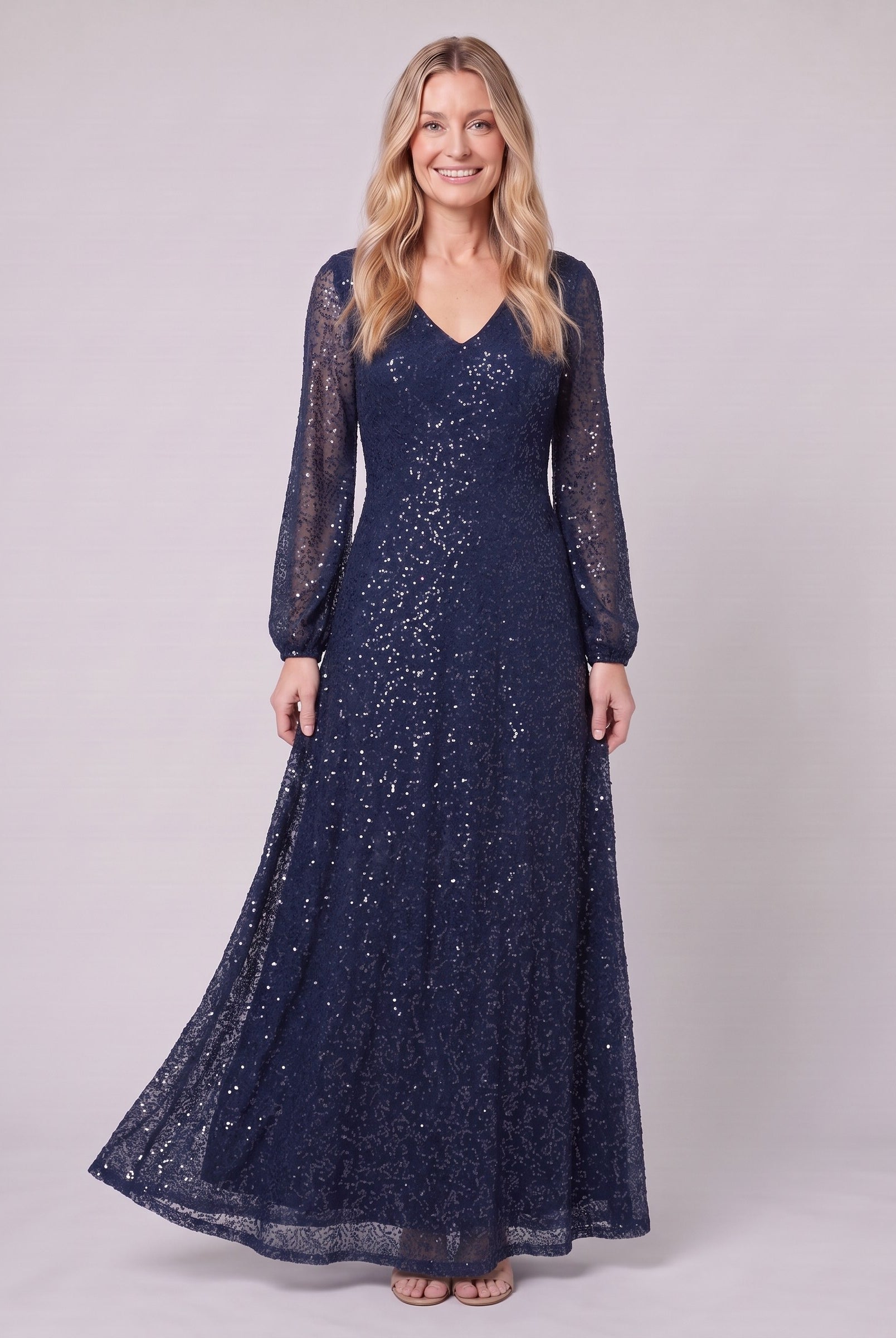 Rayven navy sequin gown holding the skirt, standing view