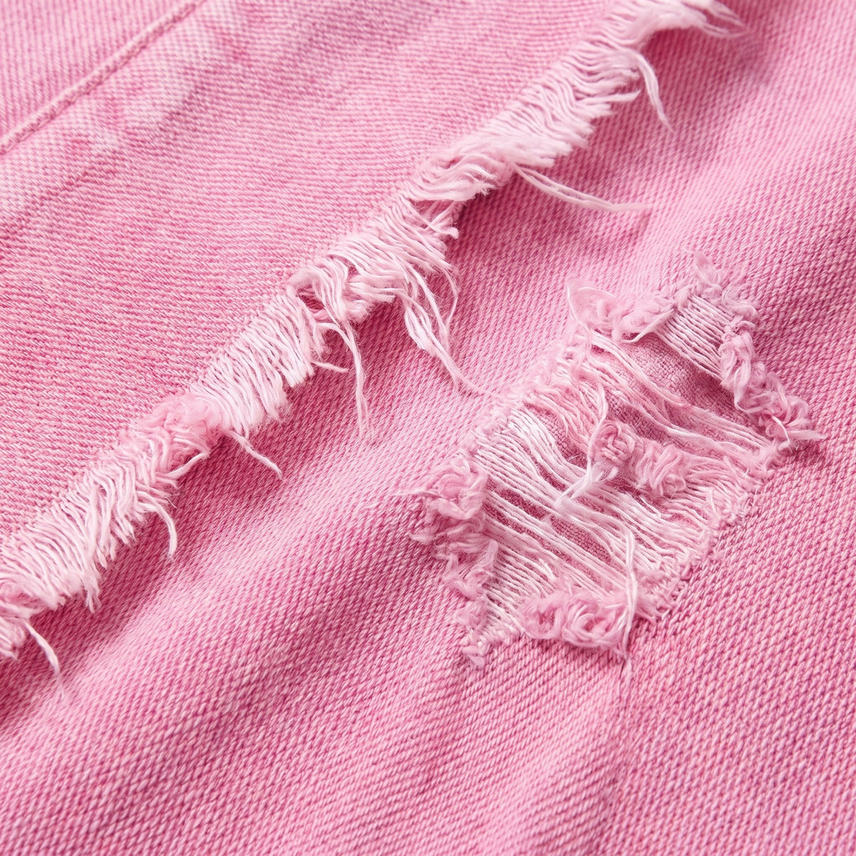 Saoirse denim shacket, close-up of the pink washed denim with frayed distressing