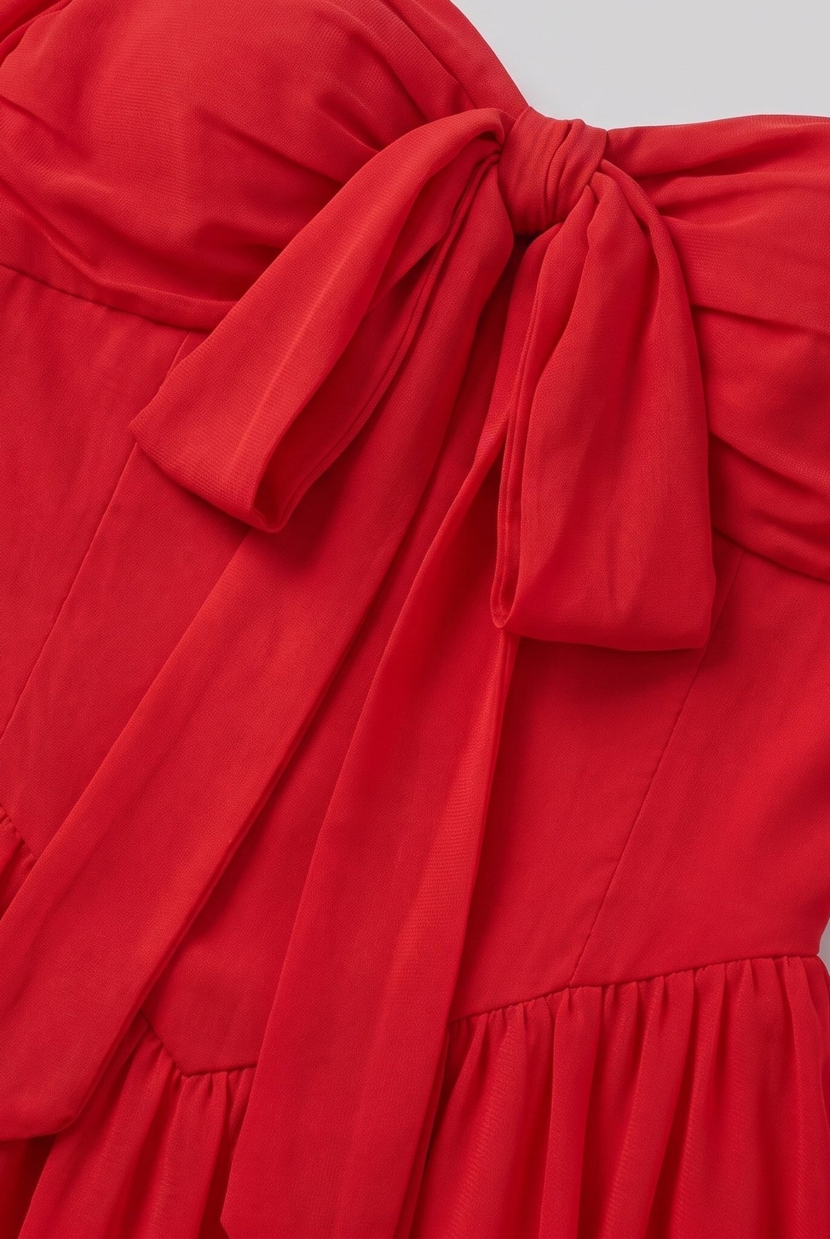 Close-up of the bow detail and knife pleats on the Scarlet Muse mini dress