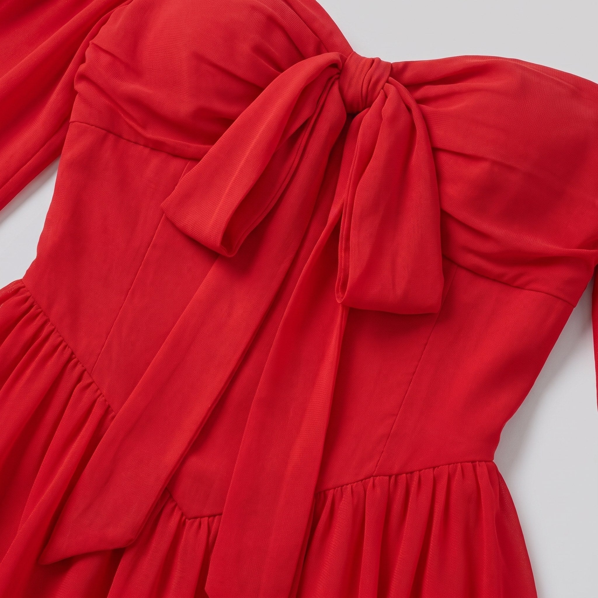 Close-up of the bow detail and knife pleats on the Scarlet Muse mini dress