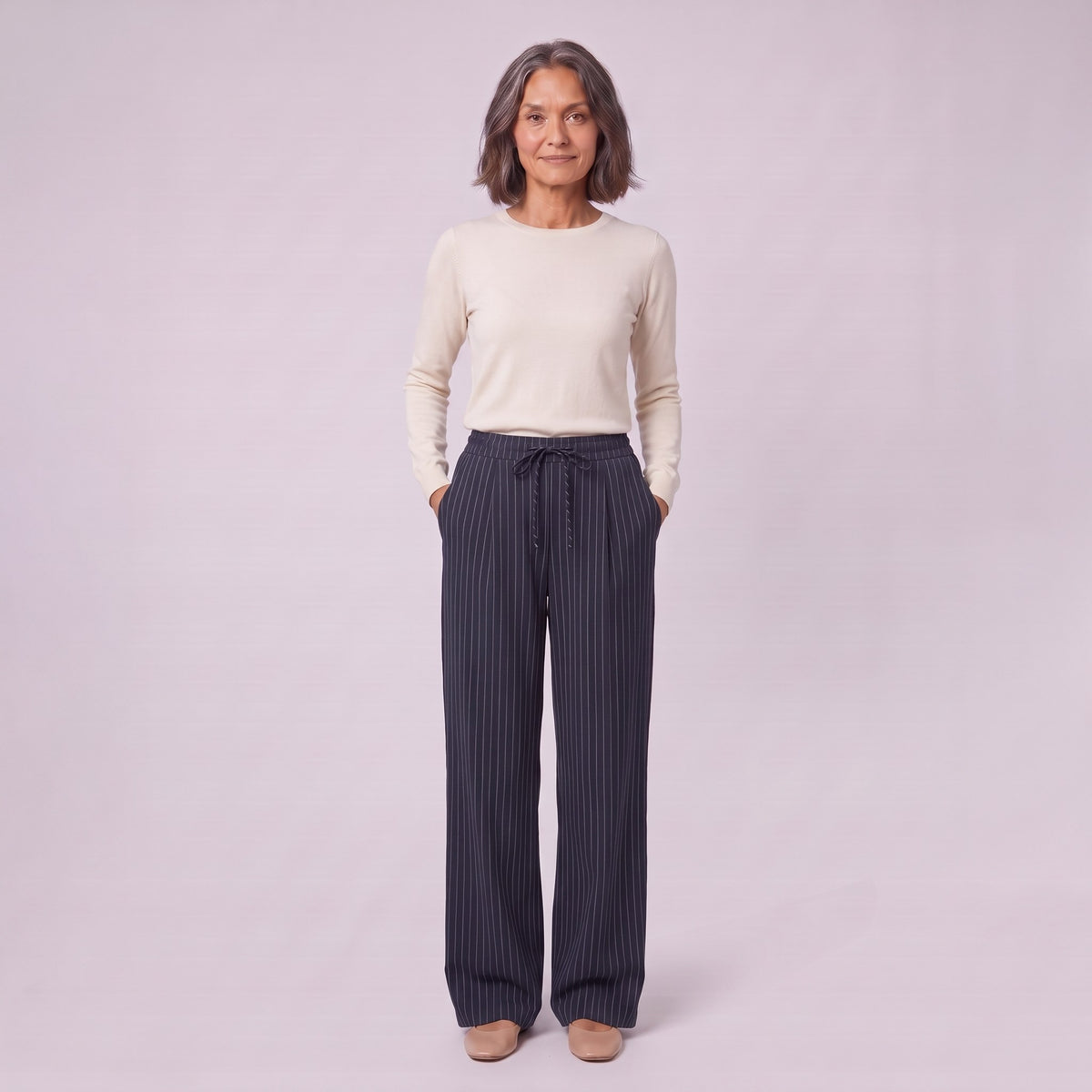 Sidony pinstripe wide leg trousers in navy blue, full-length view with hands in the pockets