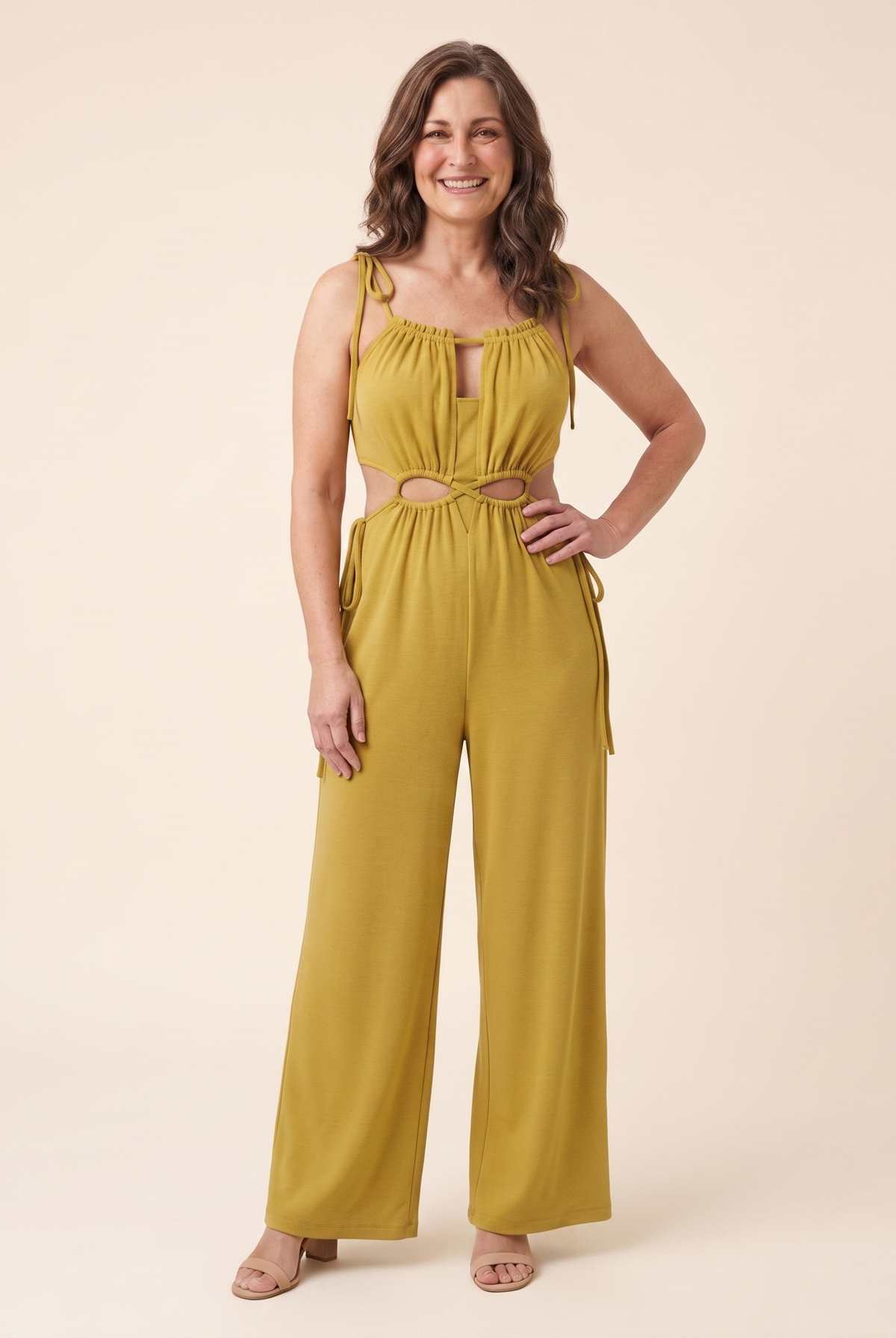 Mustard jumpsuit with a cut-out waist and adjustable tie front, front view