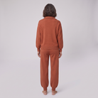 Fjorda half-zip knit lounge set in rust, back view on model