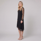 Genevieve sheer sleeve evening dress in black, side view on model