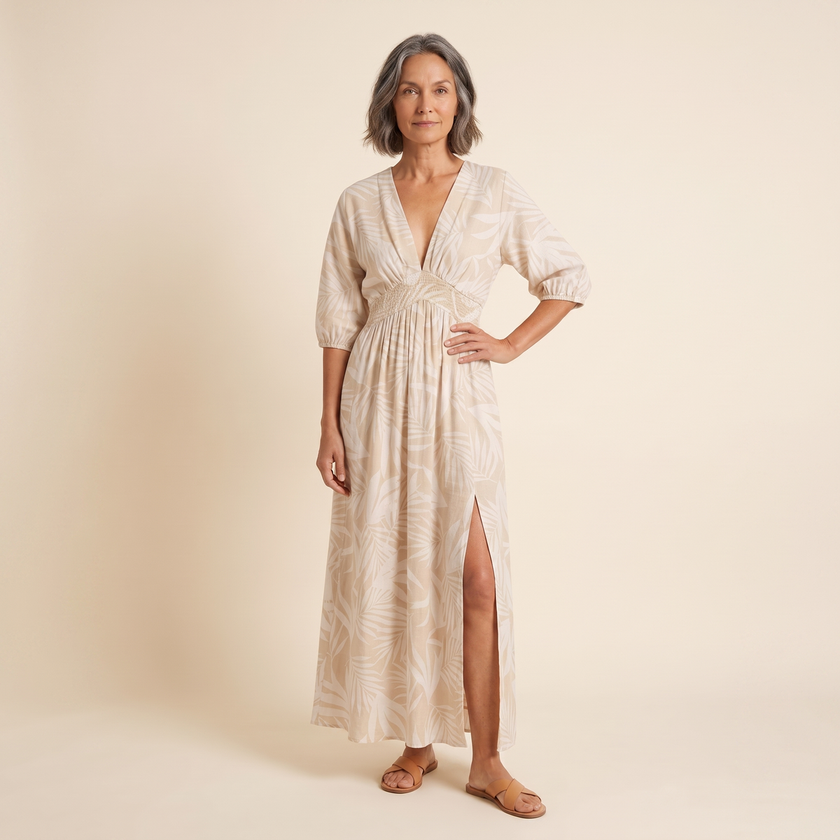 Women's beige tropical print A-line maxi dress, front view on model, warm cream studio background
