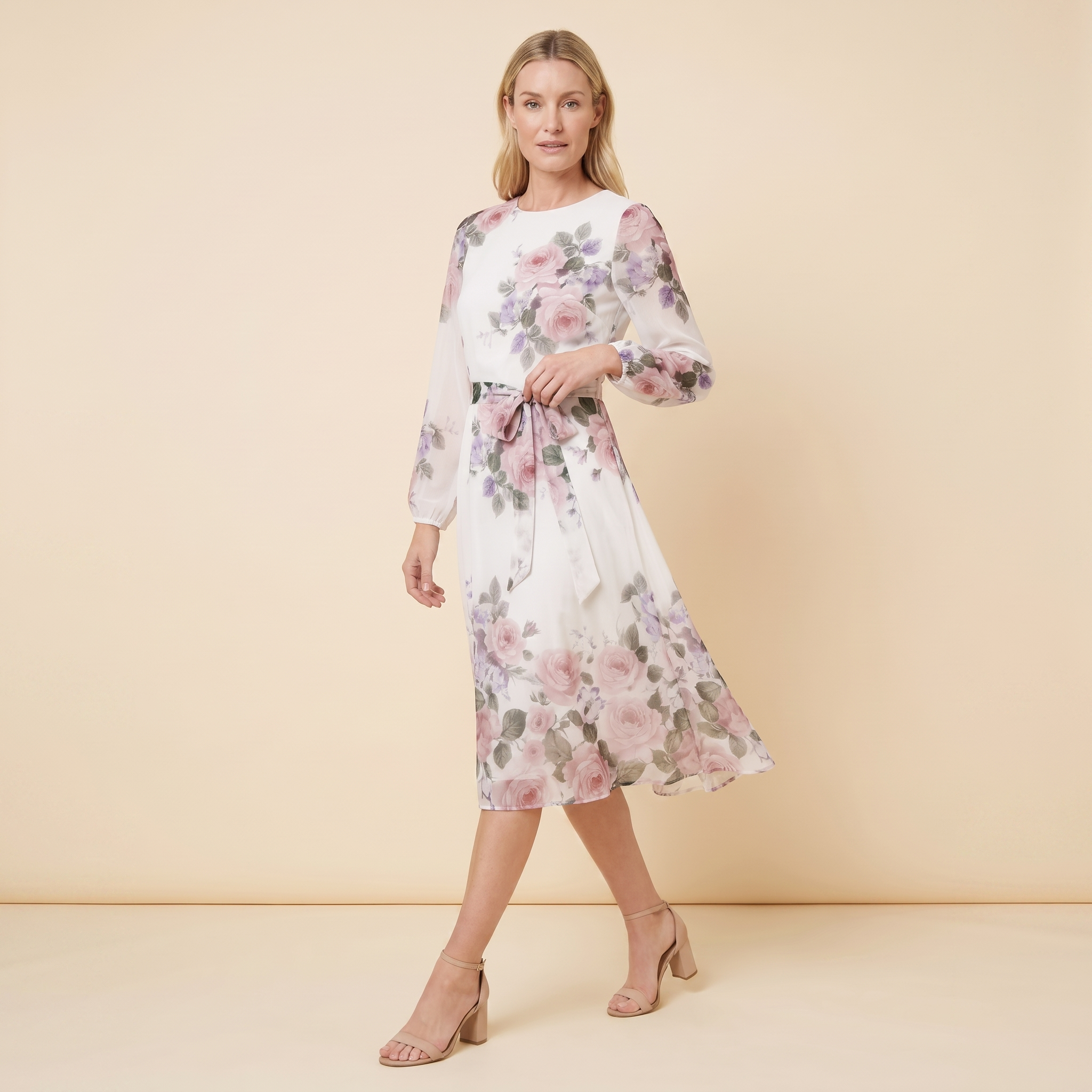 Model wearing white floral A-line midi dress with tie belt, walking pose