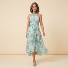 Poppy Dress green floral halter midi walking pose on model