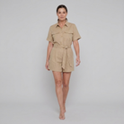 Beige utility romper with button front, walking pose on model
