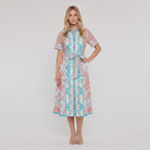 Women's white A-line collared midi dress with button front and tie belt, full-length model photo