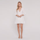 White cotton-linen tiered mini dress with lace V-neck, front view