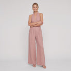 Dusty rose pink halter-neck wide-leg jumpsuit, arms crossed