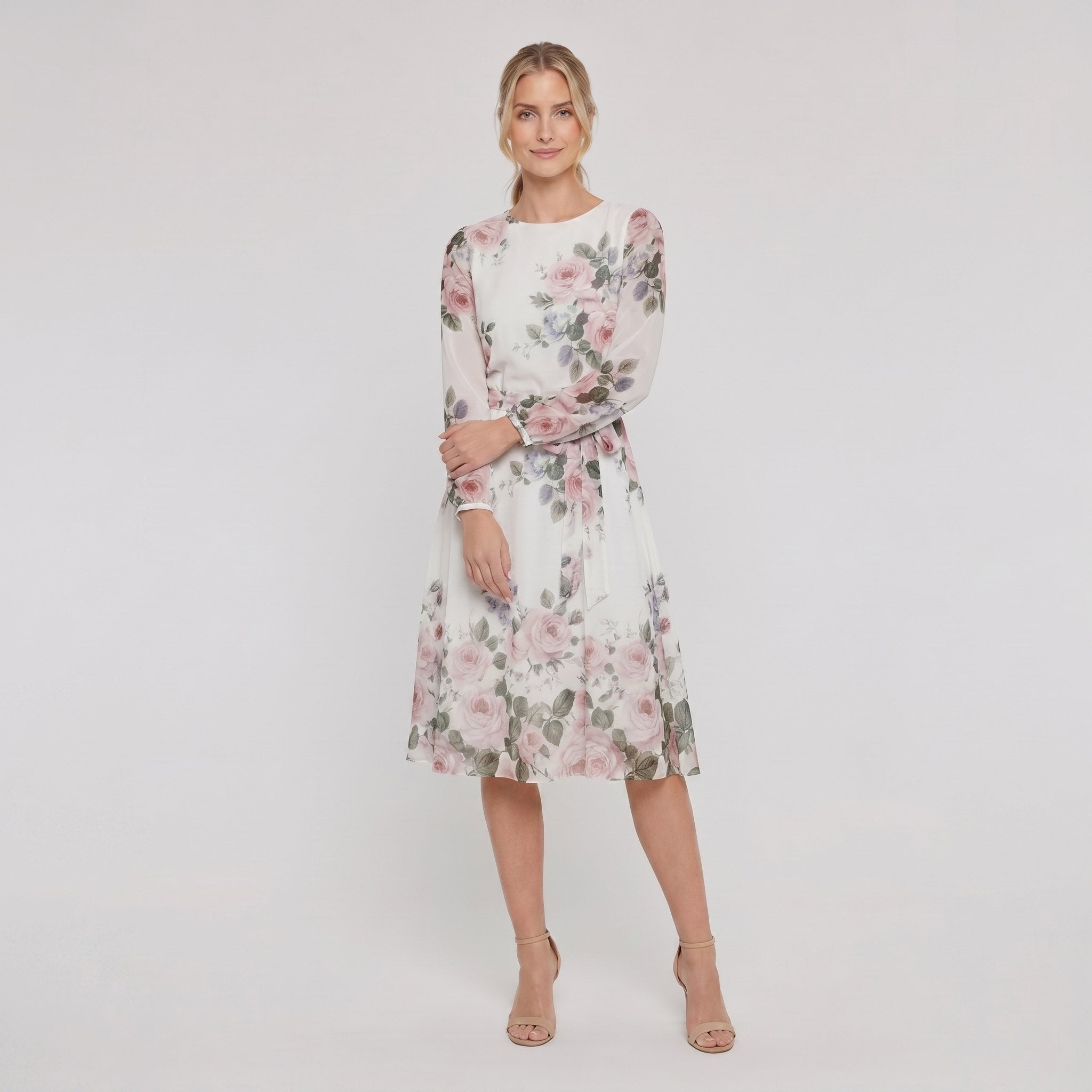 Model wearing white floral A-line midi dress with tie belt, relaxed pose