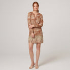 Model wearing brown floral V-neck long-sleeve shift mini dress, relaxed pose