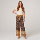 Pamela Boutique brown floral wide-leg trousers with tie belt, model front view