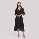Black Gina wrap midi dress with V-neck and flutter sleeves on model