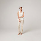 Pamela Boutique white peplum sleeveless V-neck top, model side pose