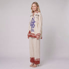 Rounelle cream linen set, three-quarter side view of shirt and wide-leg trousers