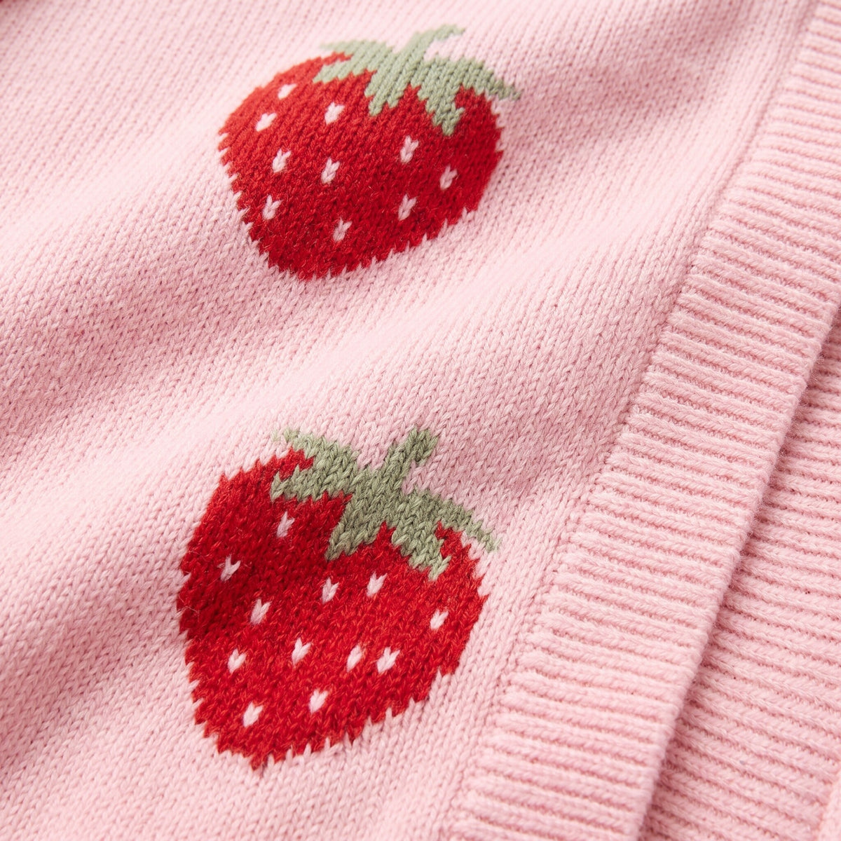Cerise cardigan fabric detail, red intarsia strawberry motif on baby pink knit