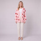 Cerise strawberry open front cardigan in pink, front view on model with cream trousers
