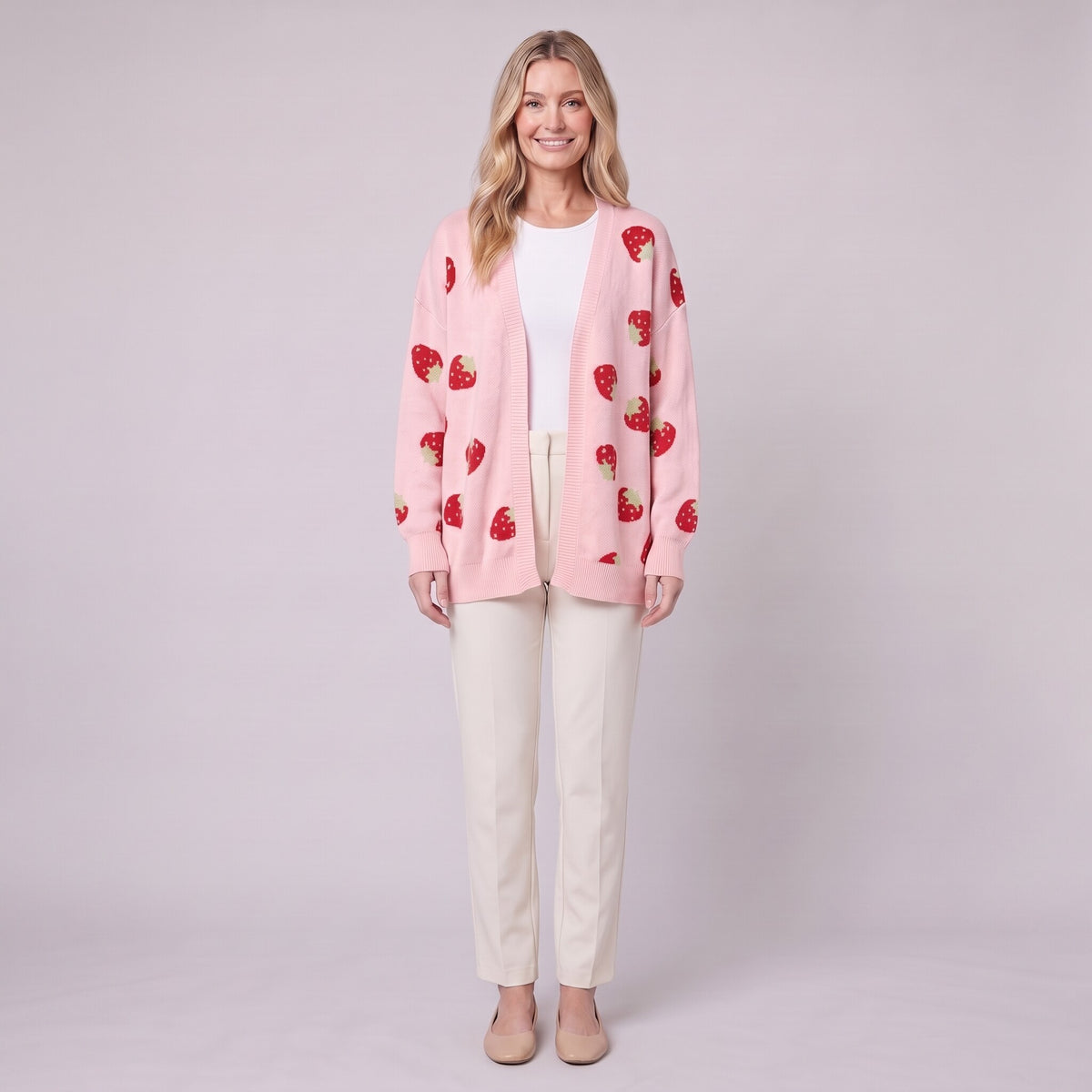Cerise strawberry open front cardigan in pink, front view on model with cream trousers