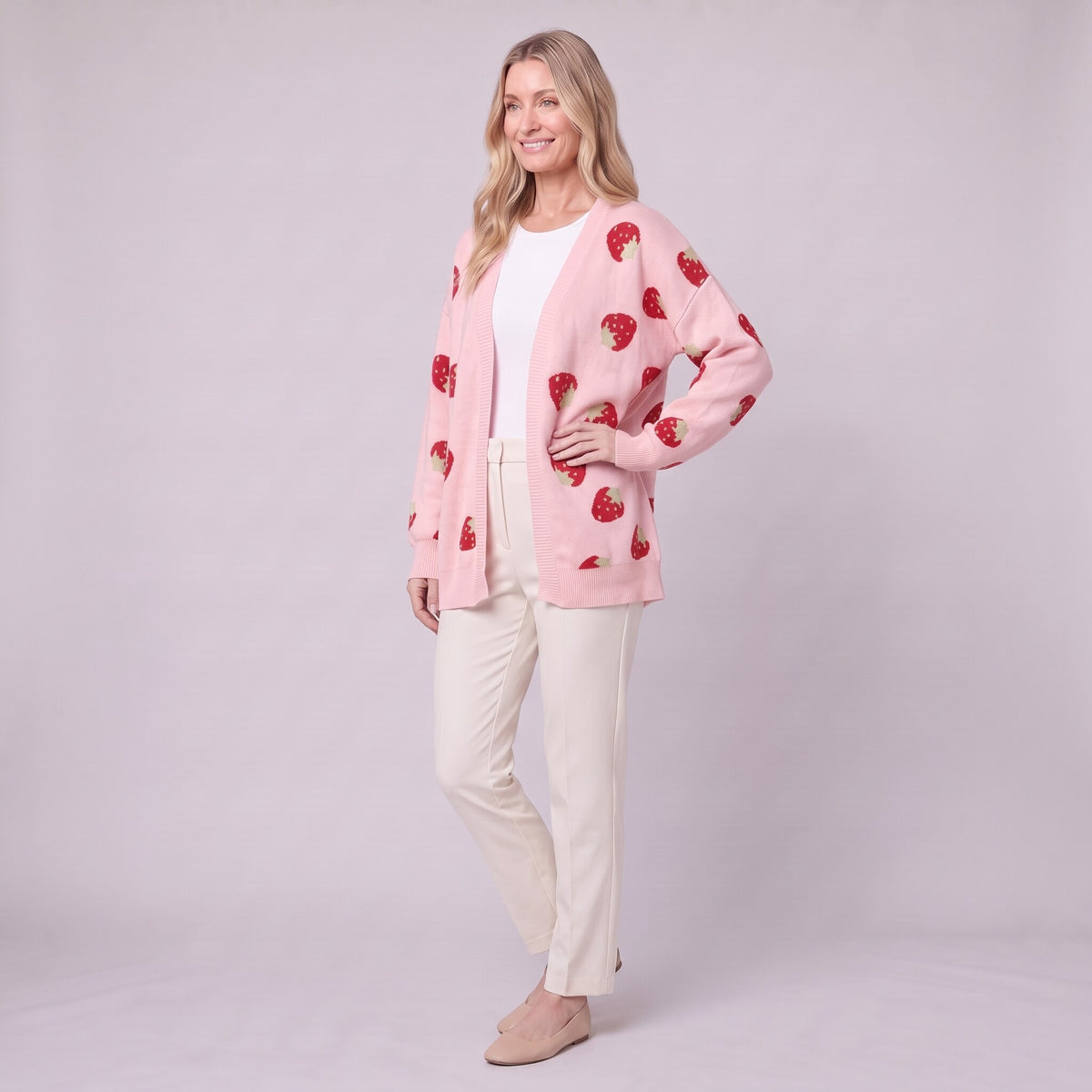 Cerise strawberry cardigan in pink, three quarter view showing strawberry motifs