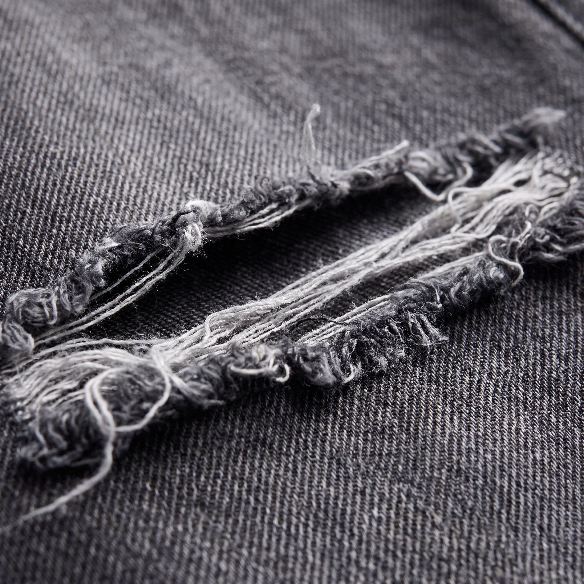 Enid baggy jeans fabric detail, distressed denim and frayed threads close-up
