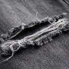 Enid baggy jeans fabric detail, distressed denim and frayed threads close-up