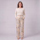 Evadne printed wide leg trousers in beige marble print, full-length view with hands in the pockets