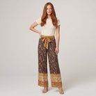 Pamela Boutique brown floral wide-leg trousers with tie belt, model front view