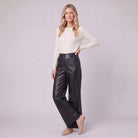 Helka faux leather wide leg trousers in black, three-quarter view showing the leather sheen