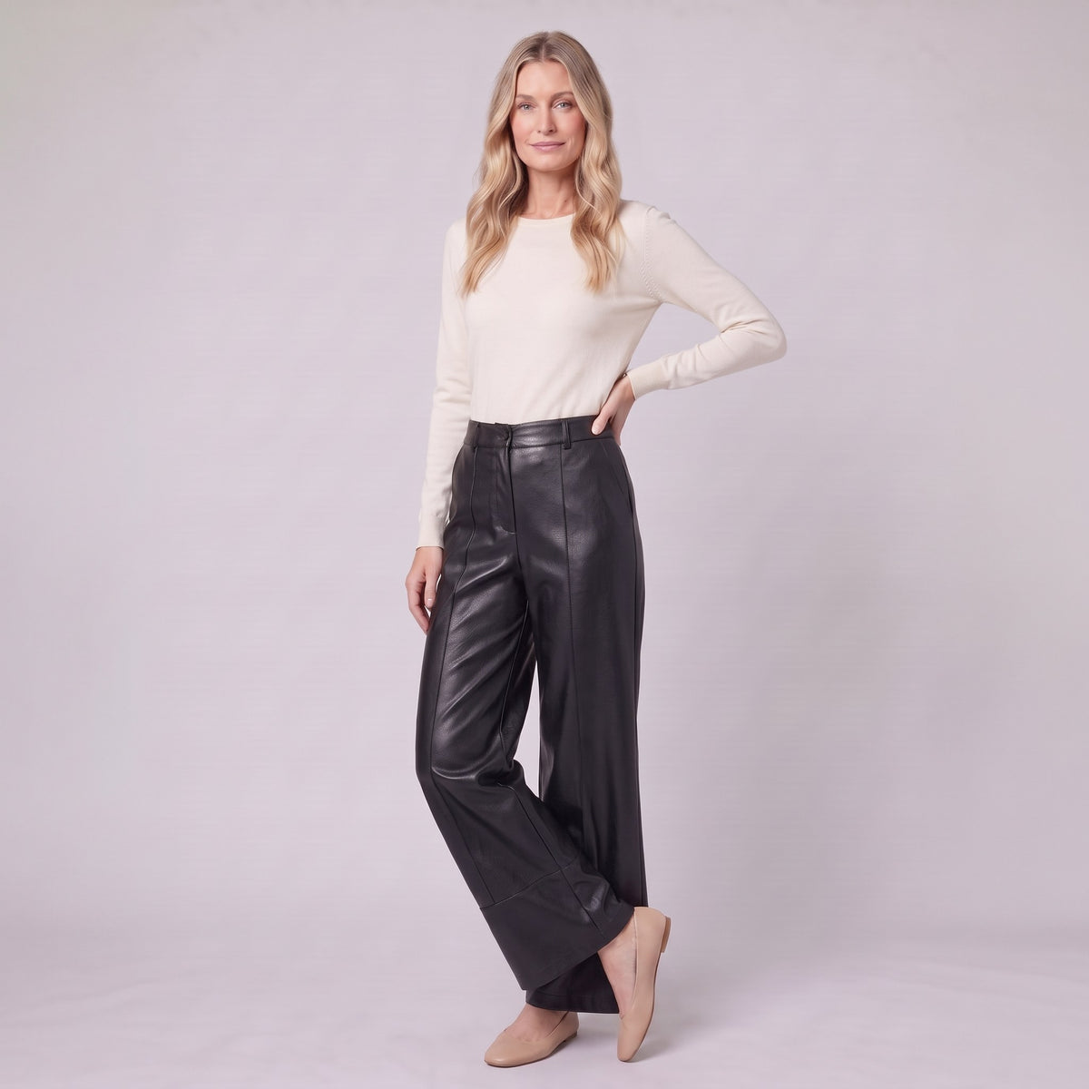 Helka faux leather wide leg trousers in black, three-quarter view showing the leather sheen