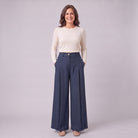 Hesper pleated wide leg trousers in navy blue, full-length view with hands in the pockets